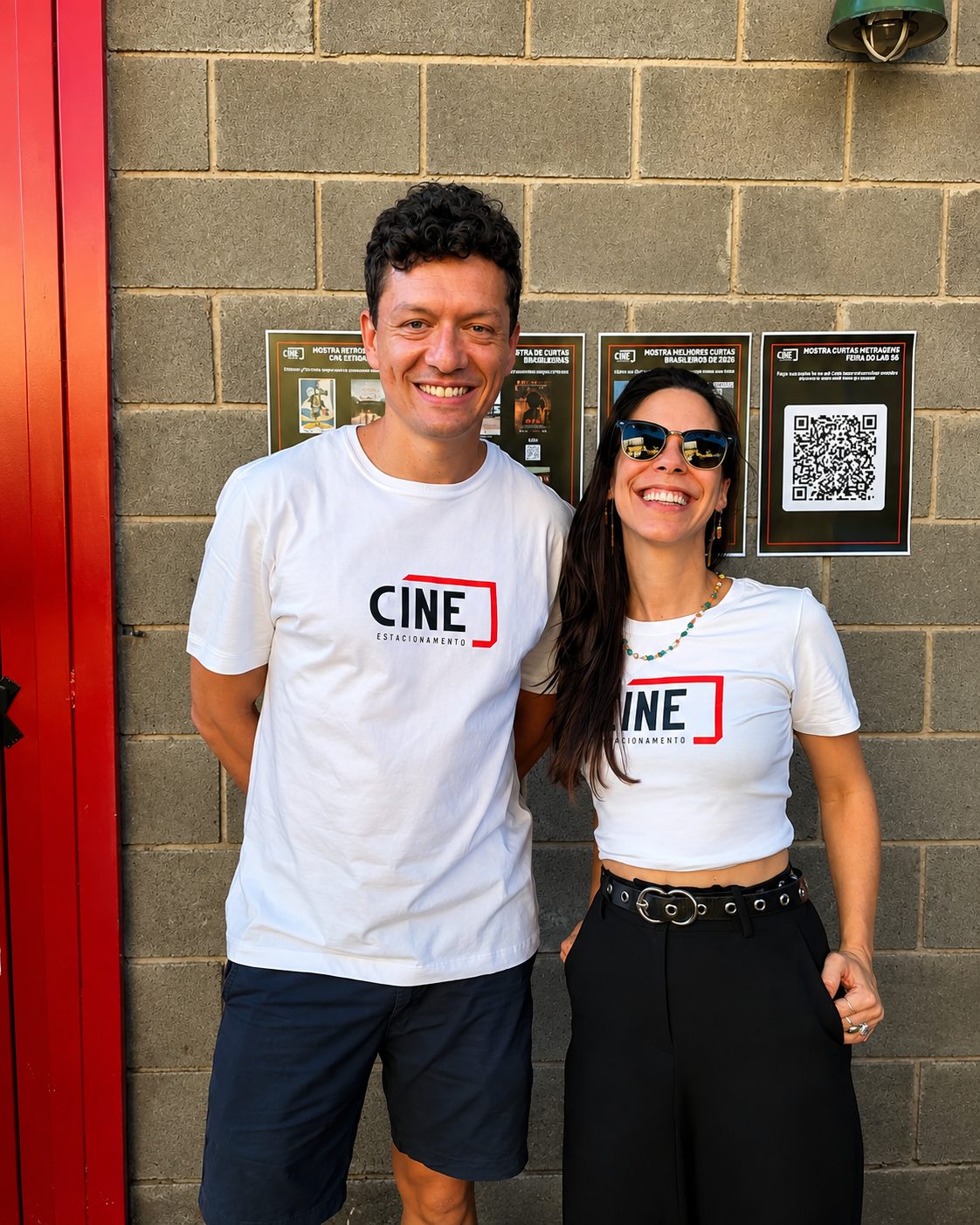 Dupla de camiseta do Cine Estacionamento na entrada, ao lado dos cartazes