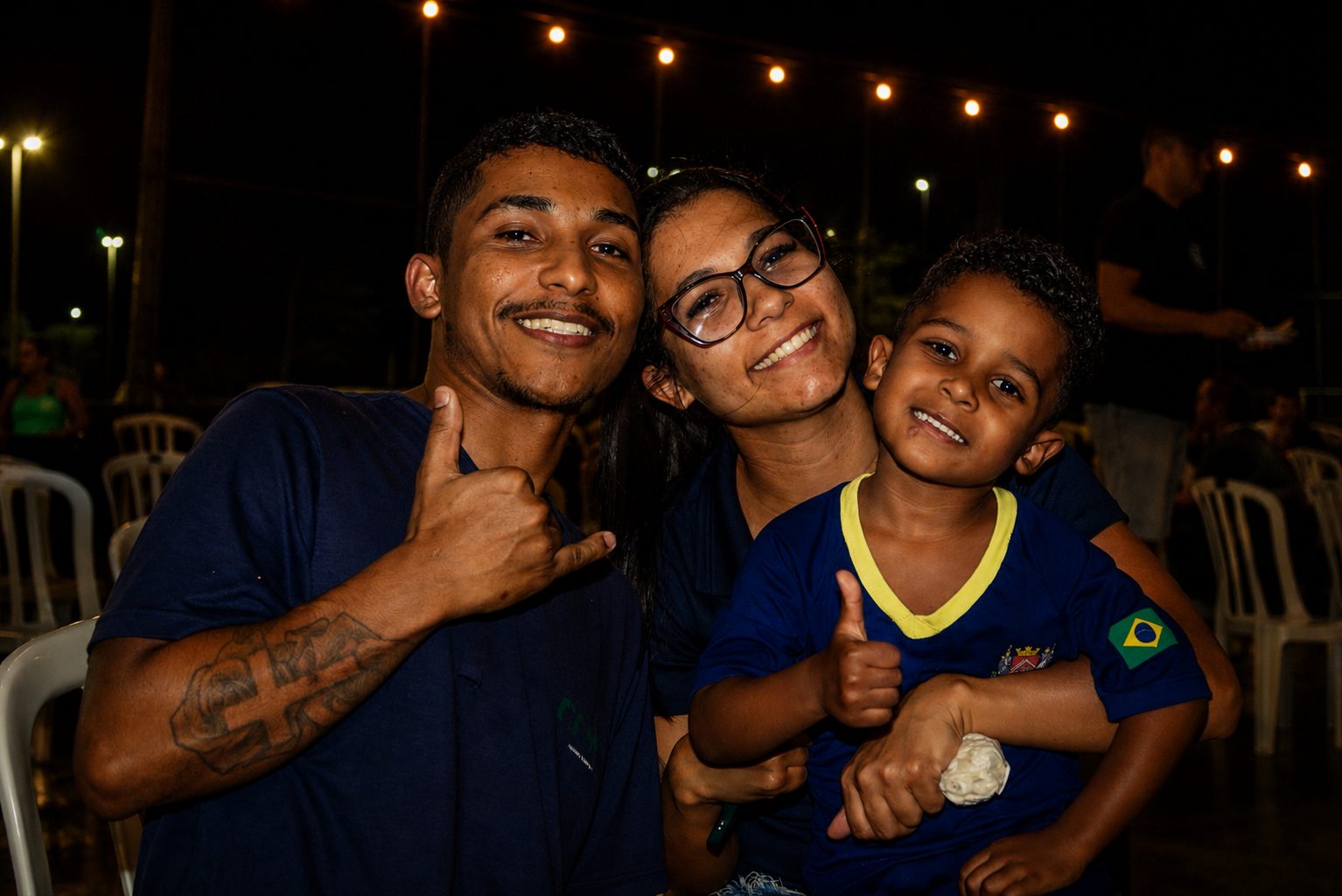 Casal com o filho pequeno posando na noite de cinema
