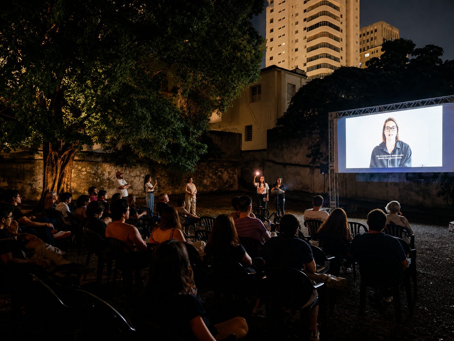 Apresentação antes do filme, com o público sentado no pátio